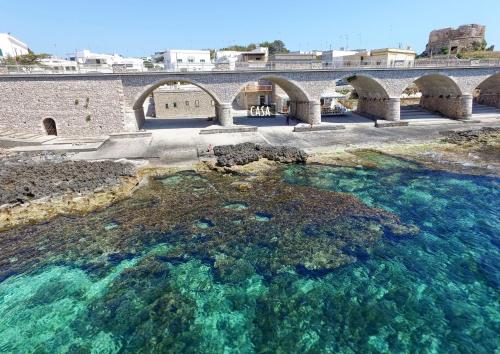 an old bridge over a large body of water at La casa in riva al mare by LoveSud in Leuca