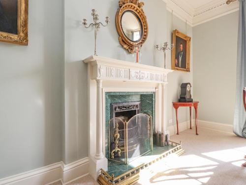 a living room with a fireplace and a mirror at Windyridge in Settle