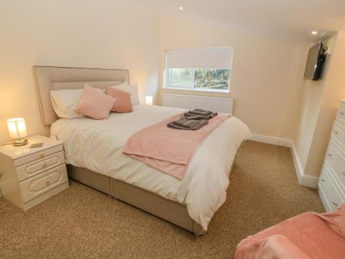 ein Schlafzimmer mit einem großen Bett und einem Fenster in der Unterkunft The Apartment at Plas Yr Eithin in Amlwch
