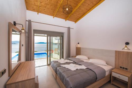 1 dormitorio con cama y vistas al océano en Amousso Bay Villas, en Marantochori