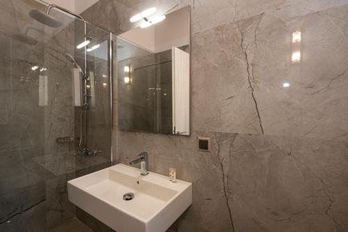 W łazience znajduje się umywalka i lustro. w obiekcie Amousso Bay Villas w mieście Marantochori
