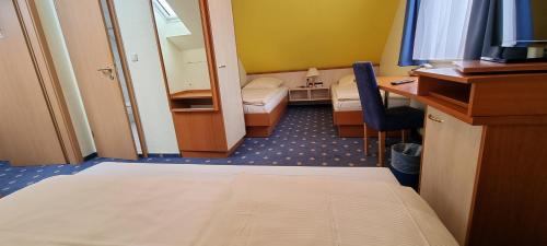 a hotel room with a bed and a desk and a mirror at Hotel Heldt in Bremen