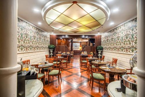 a restaurant with tables and chairs and a chandelier at The Britannia Hotel in Rome
