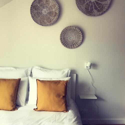 1 dormitorio con 1 cama con almohadas y platos en la pared en "La Sodilie" charmante maison de ville en Nantes