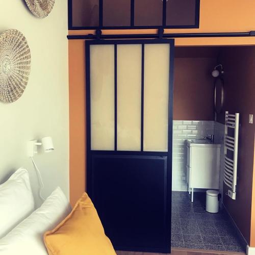 Cette chambre dispose d'une porte noire et d'un canapé blanc. dans l'établissement La Sodilie proche centre ville au calme Parking gratuit, à Nantes