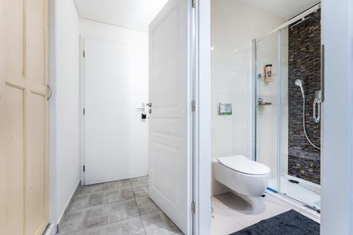 een witte badkamer met een toilet en een douche bij Get Prague Flat Stepanska in Praag