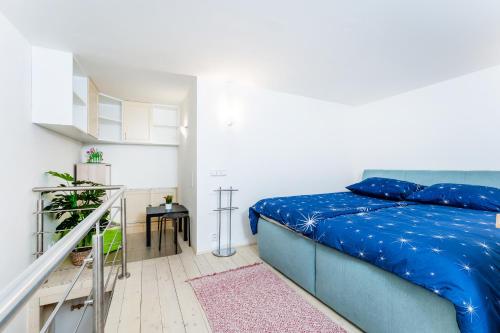 een slaapkamer met een blauw bed en een trap bij Get Prague Flat Stepanska in Praag