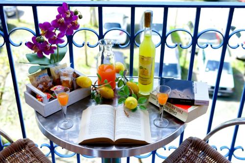 een tafel met een open boek en glazen wijn en fruit bij MaLu' B&B in Sorrento