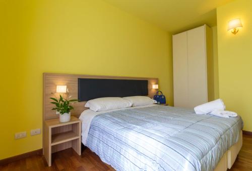 a bedroom with a large bed and yellow walls at La Pineta - Le Casette di Osvaldo in Lecco