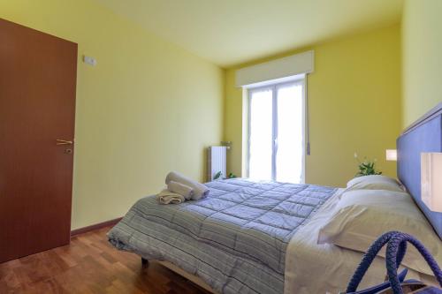 a bedroom with a bed with a blue comforter and a window at La Pineta - Le Casette di Osvaldo in Lecco