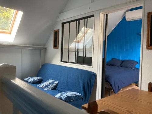 uma sala de estar com um sofá azul e uma cama em Residence Labrège T2Duplex Spa Piscine em Sargé Les Le Mans 