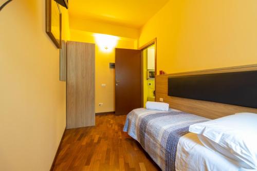 a hotel room with two beds and yellow walls at La Pineta - Le Casette di Osvaldo in Lecco