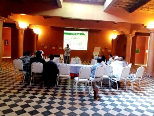a group of people sitting around a table at a presentation at kasbah Dar Bahnini in Skoura