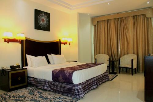 a hotel room with a bed and a table and chairs at Tourist Hotel in Doha