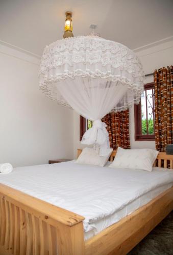a bedroom with a large bed with a chandelier at GKAT Resort in Mbarara
