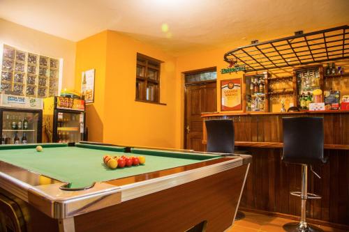 a pool table in a room with a bar at Fort Motel in Fort Portal