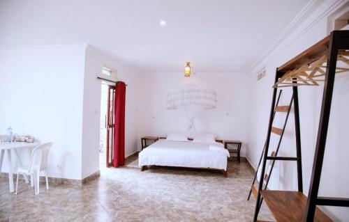 a white bedroom with a bed and a ladder at GKAT Resort in Mbarara