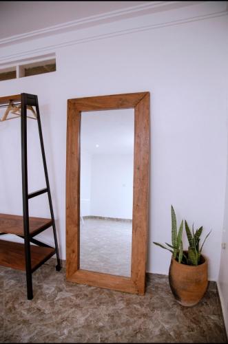 a mirror in a room with a ladder and a plant at GKAT Resort in Mbarara