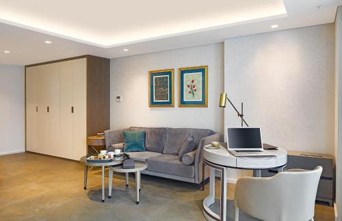 a living room with a couch and a table with a laptop at Wanda Vista Istanbul in Istanbul