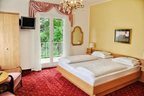 - une chambre avec un grand lit et une fenêtre dans l'établissement Hotel Zima, à Merano