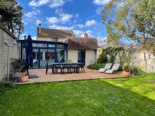 a patio with a table and chairs in a yard at Balaena - maison avec jardin proche plage in Luc-sur-Mer
