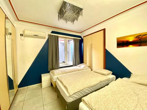 Zimmer mit 3 Betten und einem Fenster in der Unterkunft Central Park Apartments in Antwerpen