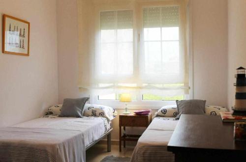 オリーバにあるApartamento de lujo en la playaのベッド2台と窓が備わる客室です。