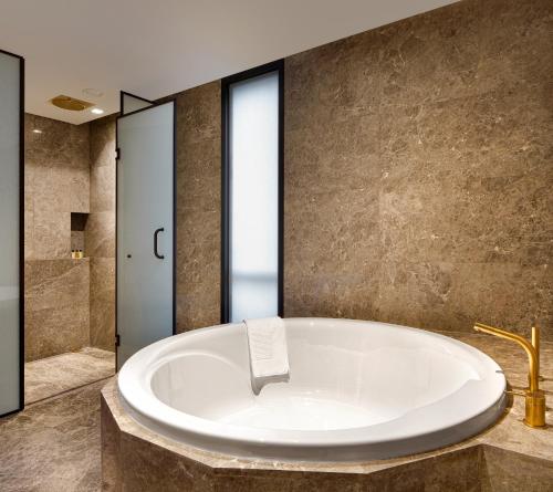 a large tub in a bathroom with a shower at Wanda Vista Istanbul in Istanbul