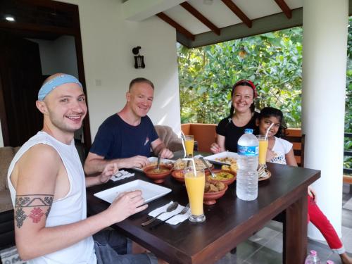 a group of people sitting around a table eating food at Sadee's Place in Dambulla