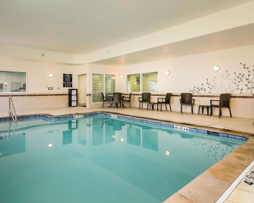 une piscine dans un hôtel avec des chaises et des tables dans l'établissement Sleep Inn & Suites - Fort Scott, à Fort Scott