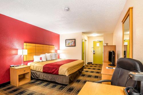 a hotel room with a bed with a red wall at Econo Lodge Wanamaker in Topeka