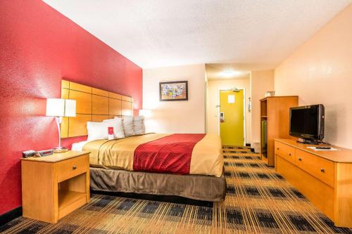 een hotelkamer met een bed en een flatscreen-tv bij Econo Lodge Wanamaker in Topeka