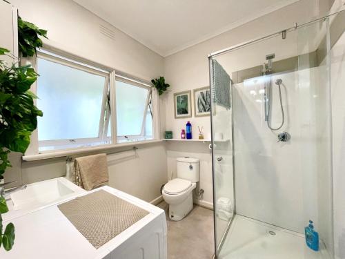 a bathroom with a shower and a toilet at Sunryes Beach House in Rye