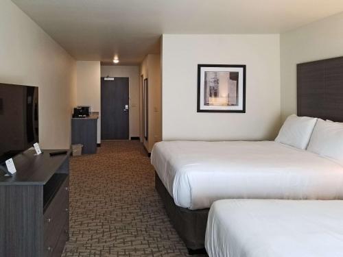 a hotel room with two beds and a flat screen tv at Comfort Inn & Suites in Medina
