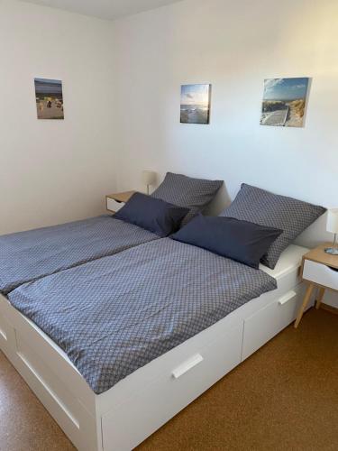 1 dormitorio con 2 camas y almohadas azules en Ferienhaus „Kleinheide 18”, en Großheide