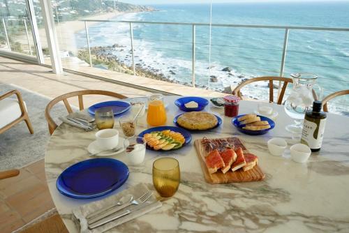 a table with plates of food and a view of the ocean at Iris Zahara in Zahara de los Atunes