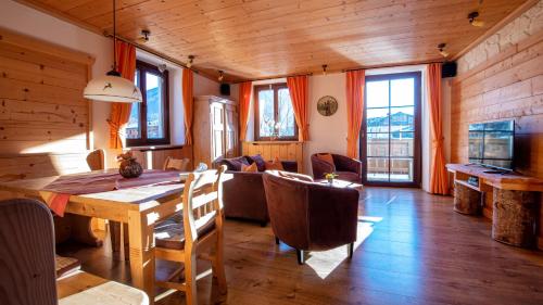 a dining room with a wooden table and chairs at Apartments Landhaus Sonnheim in Lofer