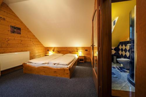 代什特納的住宿－Srub Karolina，一间卧室配有一张床,一间卫生间位于客房内
