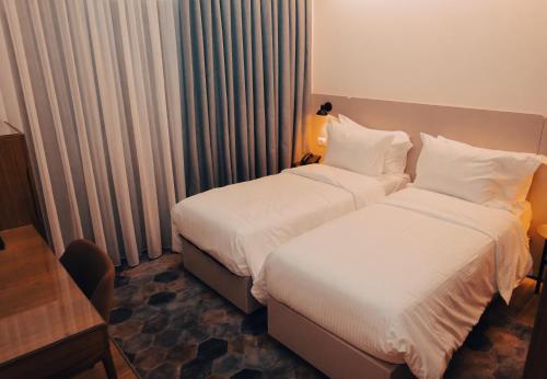 a hotel room with two beds and a desk at Hotel Theatro- City Center in Tirana