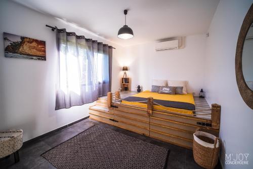a bedroom with a wooden bed and a mirror at VILLA SYLBRIA - Villa d'exception **** in Étang-Salé