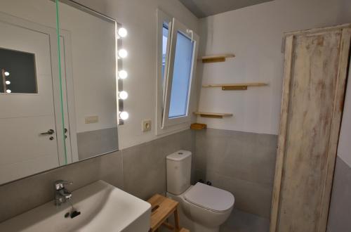 uma casa de banho com um WC, um lavatório e um espelho. em Laduna Tarifa Penthouse / seaview & pool em Tarifa