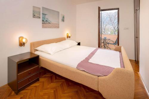 a large bed in a room with a wooden floor at Apartmani Ana Juranić in Jurandvor
