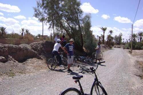 a group of people standing on a dirt road with bikes at kasbah Dar Bahnini in Skoura