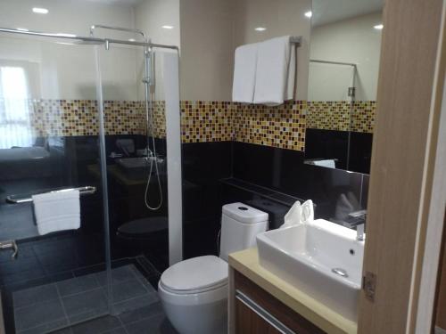 a bathroom with a shower and a toilet and a sink at Ramada Ekamai in Bangkok