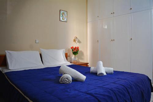 una camera da letto con un letto blu e asciugamani di Moumouri's House a Gastouri