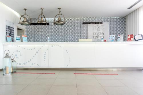 a kitchen with a white counter and blue tiles at Costa de Prata Hotel in Figueira da Foz