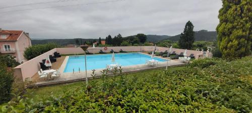 ein Pool in einem Garten mit Stühlen um ihn herum in der Unterkunft INATEL Luso in Luso