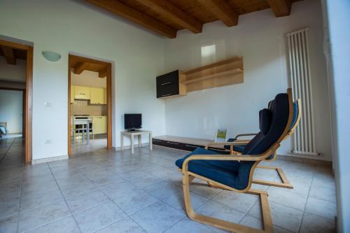 ein Wohnzimmer mit einem blauen Stuhl und einem Tisch in der Unterkunft Agriturismo Conero in Ancona