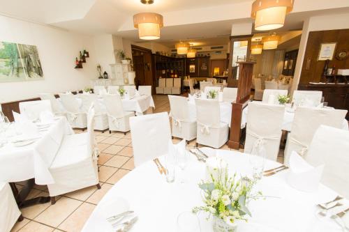 a dining room with white tables and white chairs at Hopfeld - Apartment in Stockerau