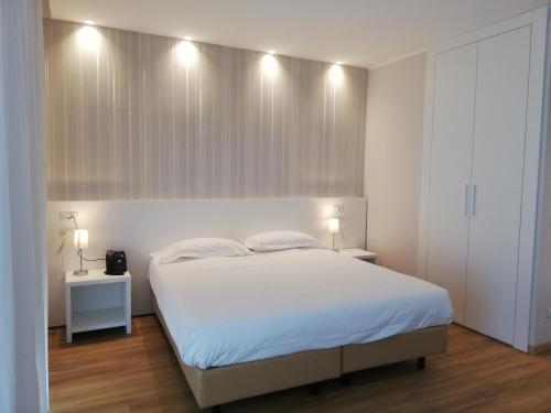 ein Schlafzimmer mit einem weißen Bett und zwei Nachttischen in der Unterkunft Novo Hotel Rossi in Verona